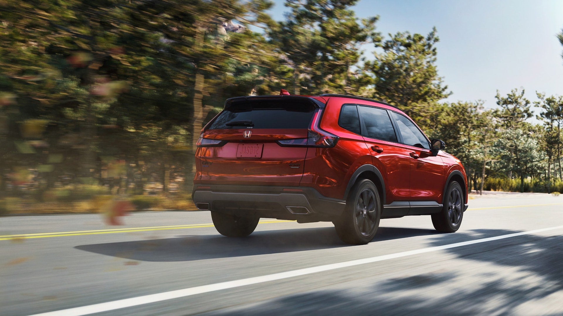 A rear view of a red Honda CR-V driving down the road