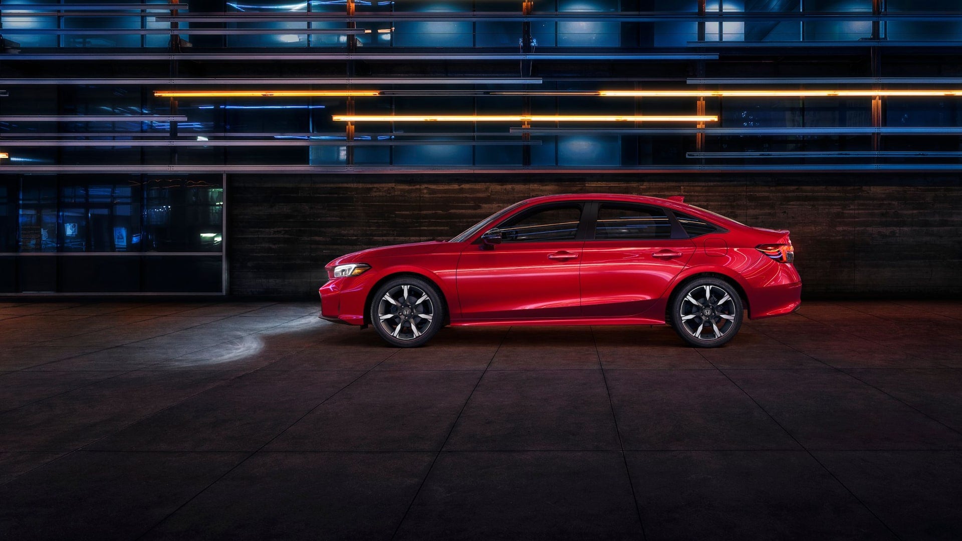 A red 2026 Honda Civic in profile at night in a city